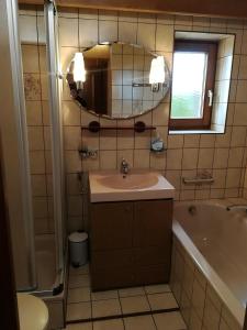 Un baño con lavabo, bañera y espejo. en Ferienhaus Gundolf Christine & Peter, en Arzl im Pitztal