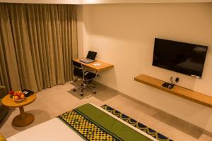 a living room with a laptop on a desk and a television at Regency Tirunelveli By GRT Hotels in Tirunelveli