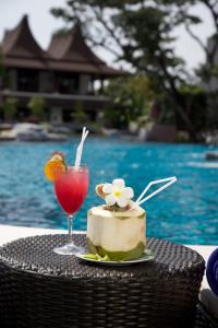 a cake and a drink on a table by a pool at The Elements Krabi Resort - SHA Plus in Klong Muang Beach