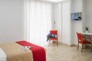 een slaapkamer met een bed en een tafel en stoelen bij Palazzo Della Mura in Angri