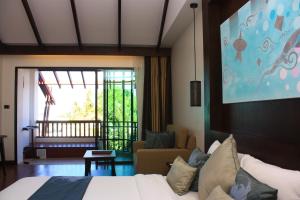 a hotel room with a bed and a living room at The Elements Krabi Resort - SHA Plus in Klong Muang Beach
