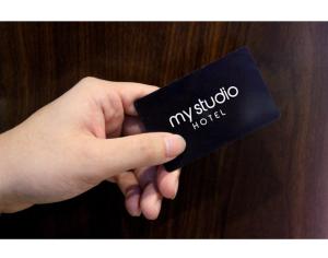a hand holding a black card with my studio hotel at My Studio Hotels Kualanamu Airport Medan in Medan