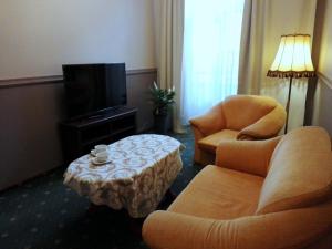 a hotel room with two chairs and a table and a tv at Bristol Residence in Bytom