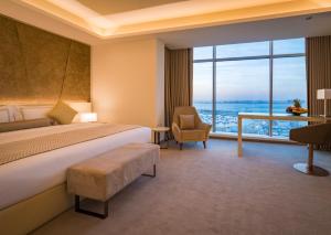 a hotel room with a bed and a large window at The Grove Hotel & Conference Centre Bahrain in Manama