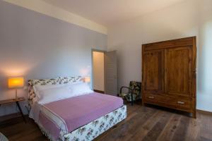 a bedroom with a bed and a wooden cabinet at La Milzetta in Russi +4 photos