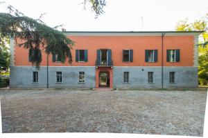 an orange and gray building with a courtyard at La Milzetta in Russi