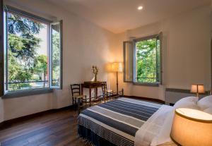 a bedroom with a bed and two windows at La Milzetta in Russi