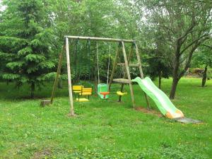 een speeltuin met een glijbaan en een schommel bij Gite Le Village in Normier