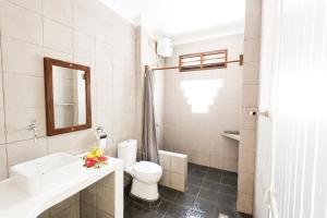 a bathroom with a toilet and a sink and a mirror at Indra Valley Inn Bukit Lawang in Bukit Lawang