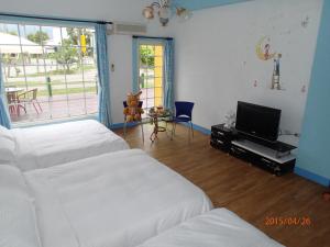 關山的住宿－花田村民宿，一间卧室配有两张床和一台平面电视
