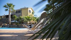 una fila di sedie a sdraio accanto alla piscina di Villa Tresino B&B a Santa Maria di Castellabate