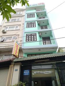 un grand bâtiment avec un panneau devant lui dans l'établissement Ngoc Loan Hotel, à Hô-Chi-Minh-Ville