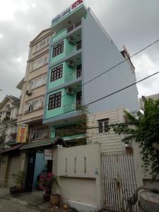 un grand bâtiment blanc avec un bleu dans l'établissement Ngoc Loan Hotel, à Hô-Chi-Minh-Ville