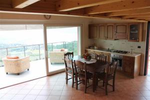 eine Küche mit einem Tisch und Stühlen sowie einen Balkon in der Unterkunft Residenza Roggiolo in Luino