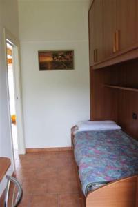 małą sypialnię z łóżkiem w pokoju w obiekcie Residenza Roggiolo w mieście Luino