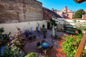 an outdoor patio with tables and chairs and flowers at Rosen Villa Sibiu in Sibiu