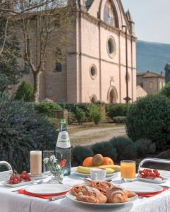 a table with plates of food and a church at Country House La Padronale Del Rivo in Rivotorto