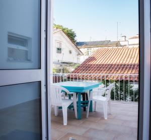 einen blauen Tisch und zwei weiße Stühle auf einer Terrasse in der Unterkunft Olive Street House in Coimbra