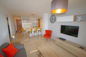 a living room with a couch and a table with chairs at LA PERLA by RENTMEDANO superb luxury duplex, private roof terrace, ocean view, pool, WiFi and parking in El Médano