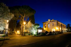 Una casa con luces de Navidad en una calle por la noche en Relais Il Postiglione - Antica Posta dei Chigi, en Campagnano di Roma