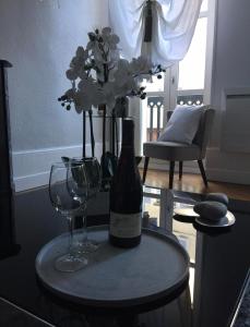 einen Tisch mit einer Flasche Wein und zwei Gläsern in der Unterkunft Le doux rendez-vous in Beaune
