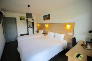 um quarto de hotel com duas camas e uma escrivaninha em Hôtel Le 15 Périgueux em Coulounieix-Chamiers