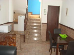a staircase in a living room with a table and chairs at Apartamento Costa Esmeralda in Bombinhas