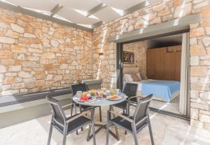 een eetkamer met een tafel en stoelen en een slaapkamer bij Paxoi Resort - Adult-Only in Gaios