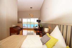 Schlafzimmer mit einem Bett, einem Schreibtisch und einem Fenster in der Unterkunft Hotel Rheingold in Gernsheim