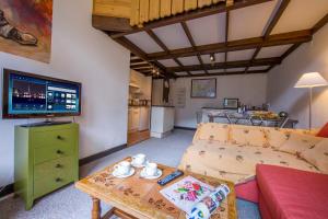 - un salon avec un canapé et une télévision dans l'établissement Résidence Grand Roc - Bruyères 207 - Happy Rentals, à Chamonix-Mont-Blanc