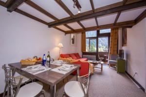 - un salon avec une table, des chaises et un canapé dans l'établissement Résidence Grand Roc - Bruyères 207 - Happy Rentals, à Chamonix-Mont-Blanc