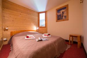 a bedroom with a bed with two towels on it at Résidence Grand Roc - Bruyères 207 - Happy Rentals in Chamonix