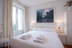ein weißes Schlafzimmer mit 2 Handtüchern auf dem Bett in der Unterkunft BREATHTAKING TERRACE VIEWS in luxury apartment - by www,SanSebastianApartments,es in San Sebastián