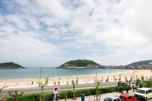a view of a beach with cars parked on the road at BREATHTAKING TERRACE VIEWS in luxury apartment - by www,SanSebastianApartments,es in San Sebastián