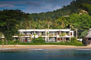 a building on the beach with the ocean at Thai Island Dream Estate in Ko Lanta