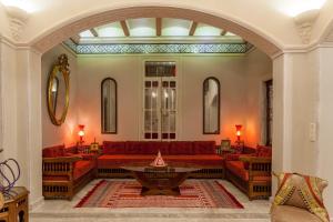 a living room with red couches and a table at Maison d'Hôtes Dar Ennassim in La Marsa