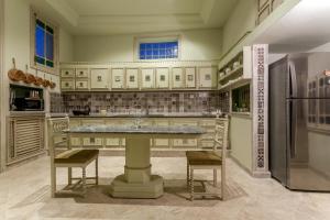 a large kitchen with a table and a refrigerator at Maison d'Hôtes Dar Ennassim in La Marsa