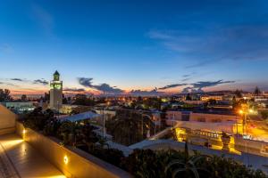 a view of a city at night with a clock tower at Maison d'Hôtes Dar Ennassim in La Marsa