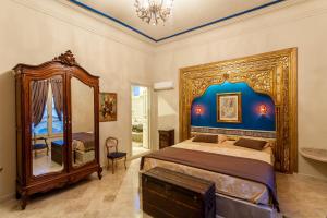 a bedroom with a large bed and a mirror at Maison d'Hôtes Dar Ennassim in La Marsa
