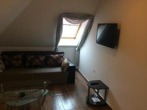 uma sala de estar com um sofá e uma janela em Hotel - Restaurant Chairite em Sófia