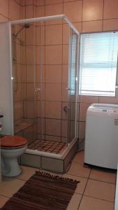 a bathroom with a shower and a toilet at La Palma Villas in Mossel Bay