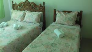 a bedroom with two beds with towels on them at Quartos Praia do Foguete Cabo Frio in Cabo Frio