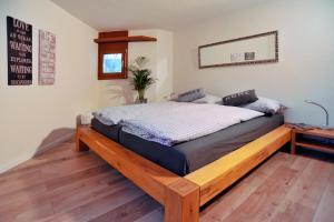 ein Schlafzimmer mit einem Holzbett in einem Zimmer in der Unterkunft Lakeside - 3.5 Zimmer Ferienwohnung am Laaxersee in Laax