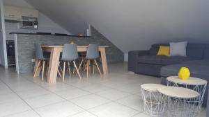 een woonkamer met een bank en een tafel en stoelen bij Ocean Appart in Saint-Gilles-les-Bains