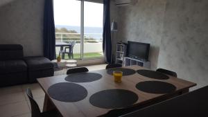 sala de estar con mesa con sillas y TV en Ocean Appart en Saint-Gilles-les-Bains