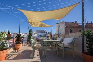 eine Terrasse mit einem Tisch und Stühlen auf dem Dach in der Unterkunft Awesome Penthouse in Sevilla