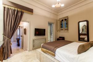 a bedroom with a large bed and a television at Maison d'Hôtes Dar Ennassim in La Marsa
