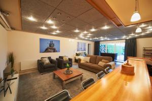 a living room with couches and a table at Harlingen Garden Apartment in Midlum