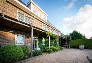 a brick building with a patio in front of it at Harlingen Garden Apartment in Midlum