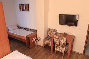a small room with a bed and a table and chairs at Pansion Centar in Tuzla